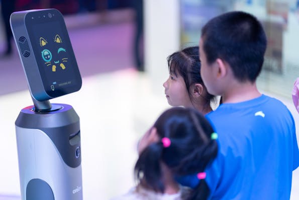 Children interact with a robot in Chongqing, China on August 27, 2019 (Shutterstock)