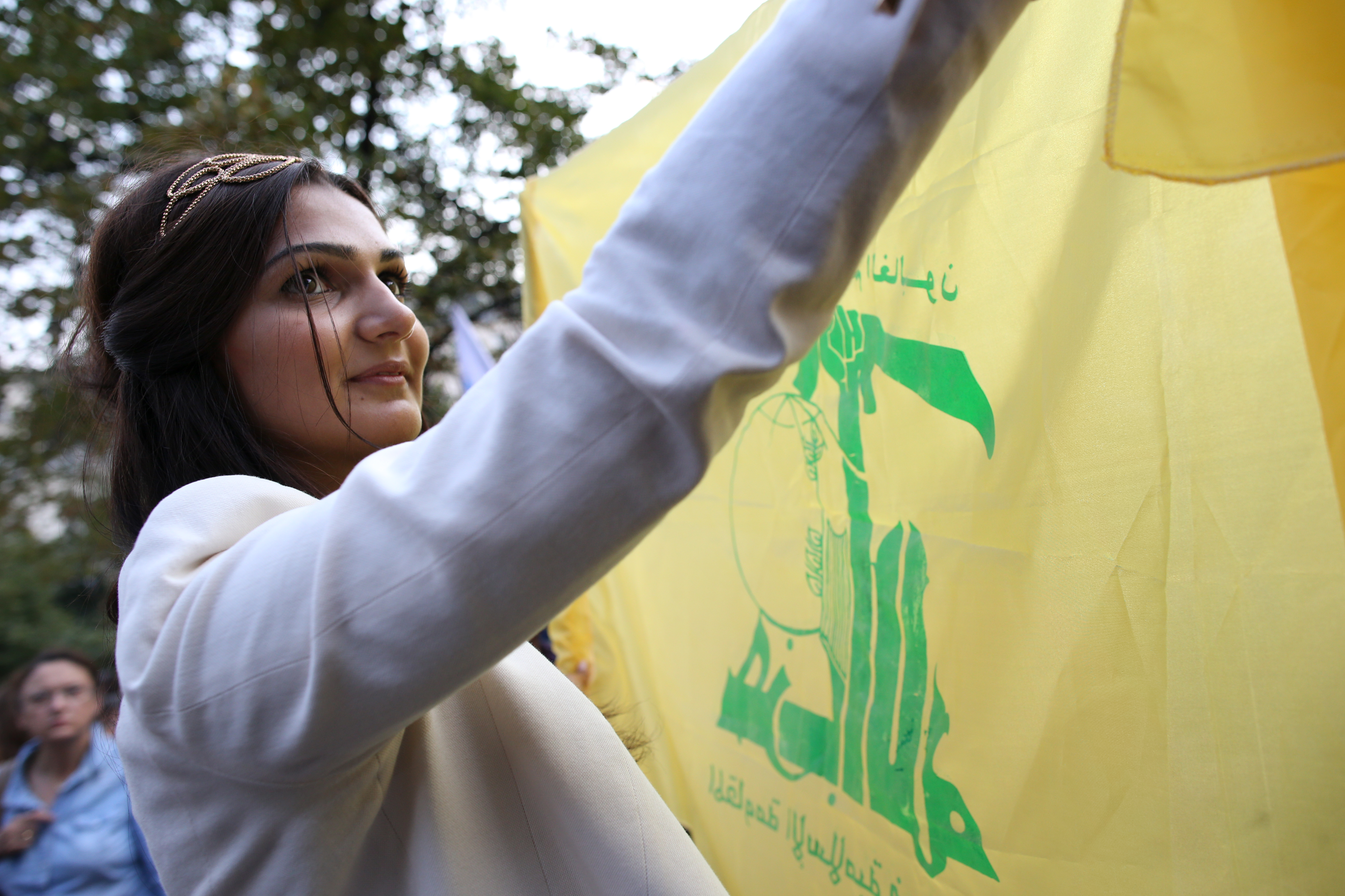 Woman with Hizballah flag at pro-Assad protest in Paris, 2013. (Kenzo Tribouillard/AFP via Getty Images)