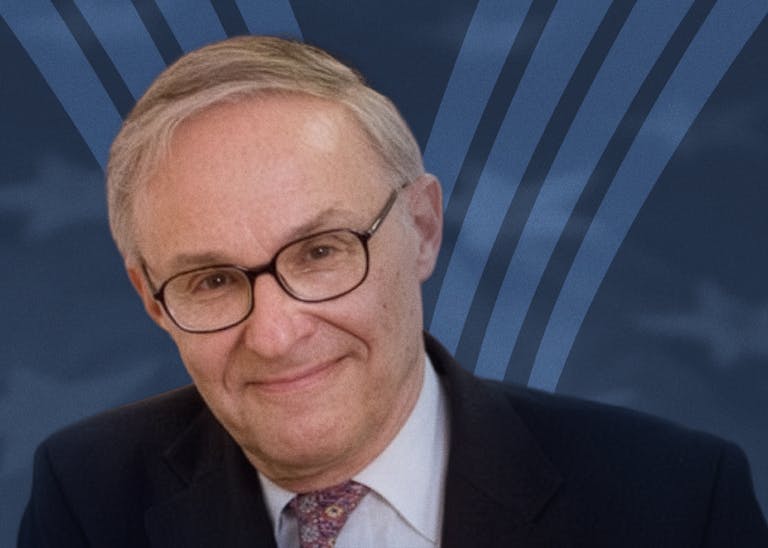 Leon Kass in front of an American flag