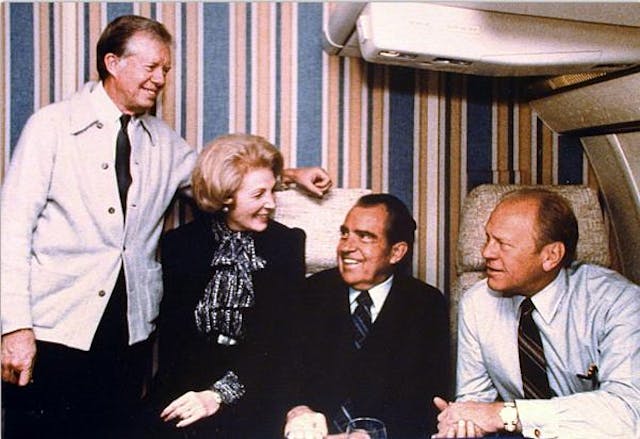 Former U.S. Presidents Jimmy Carter, Richard Nixon and Gerald Ford, pose with U.S. Chief of Protocol Leonore Annenberg during their flight from Washington to attend the funeral of Egyptian President Anwar Sadat in 1981.