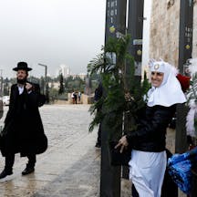 A Jewish man walks past a man dressed as Santa Claus and Russian Orthodox nuns in Jerusalem's Old City. (Photo by Gali TIbbon/ AFP via Getty Images.) A Jewish man walks past a man dressed as Santa Claus and Russian Orthodox nuns in Jerusalem's Old City. (Photo by Gali TIbbon/ AFP via Getty Images.)
