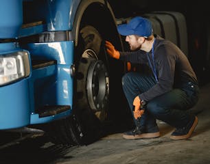 mecanieker-kijkt-wiel^-en-remsysteem-na-van-een-truck
