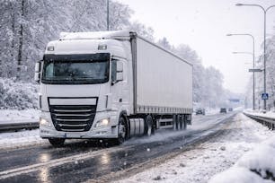 Vrachtwagen op glad wegdek met sneeuw en verminderde grip