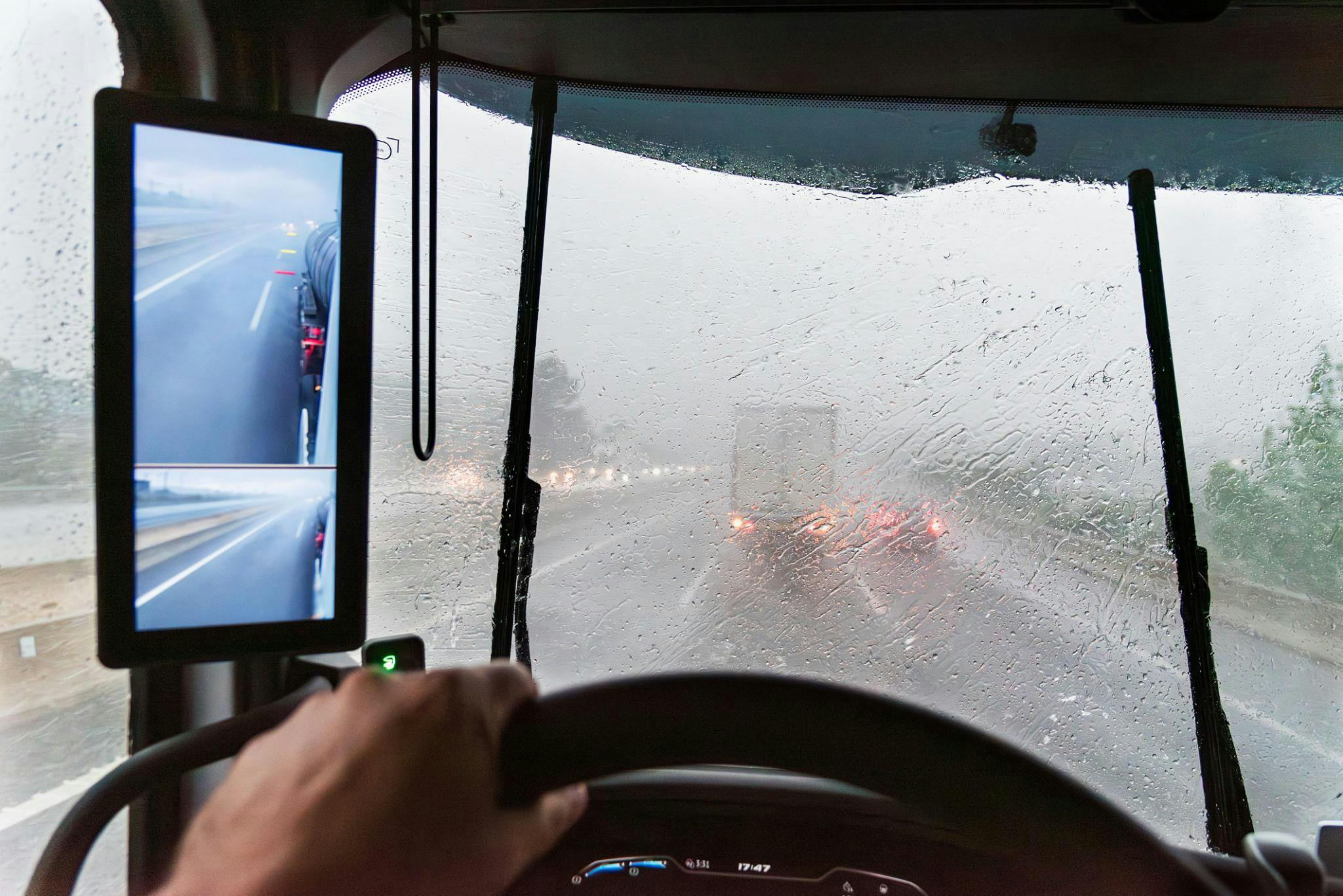 Zicht vanuit een vrachtwagencabine tijdens hevige regen met ruitenwissers in werking.