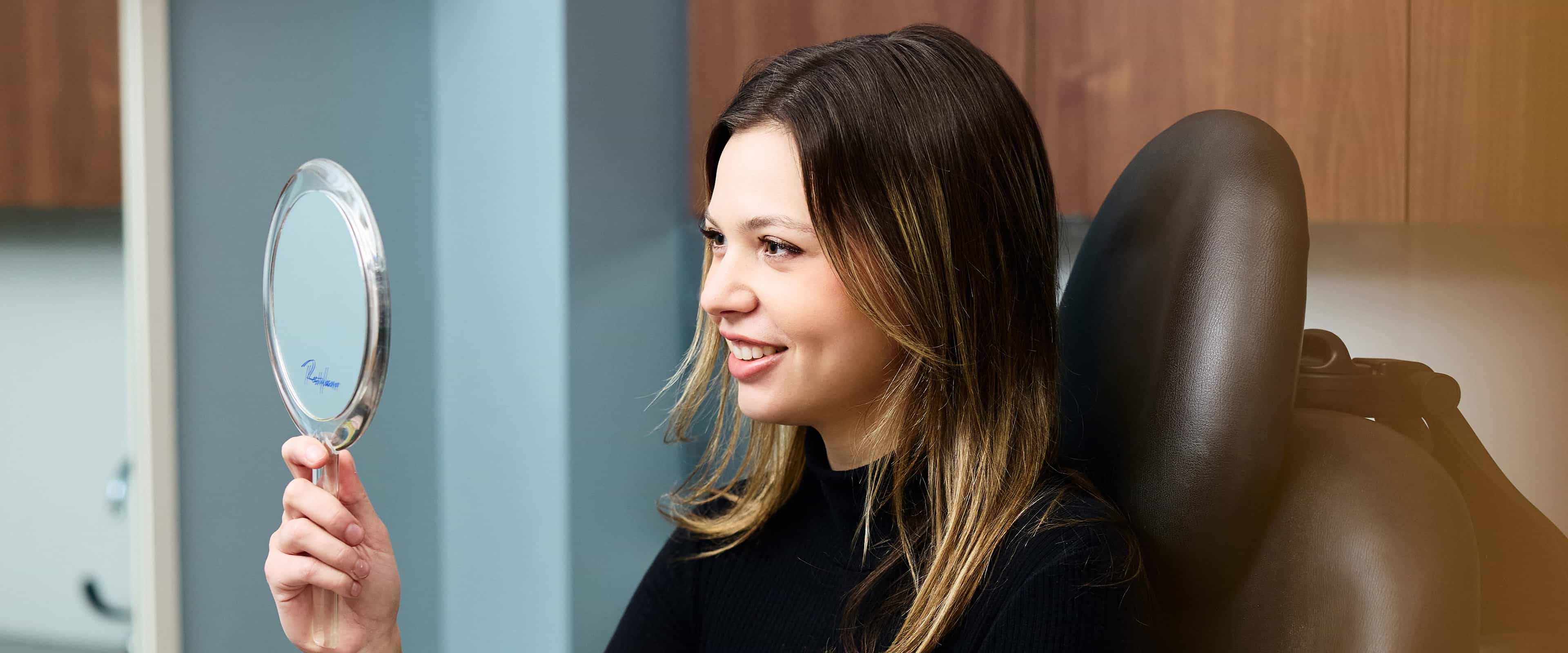 Woman looking into mirror smiling