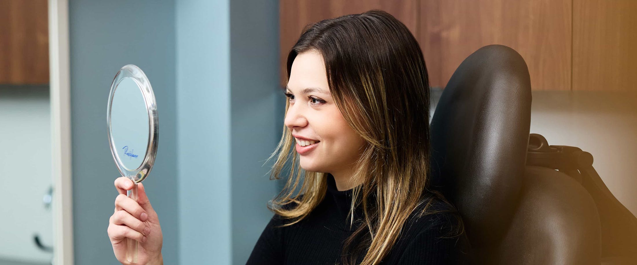 Woman looking into mirror smiling