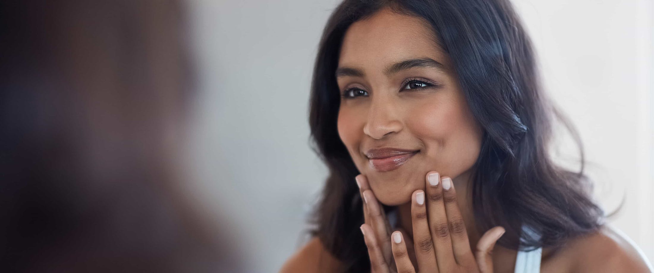 Woman looking into mirror smiling