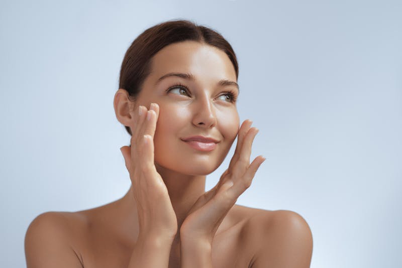woman holding her glowy face