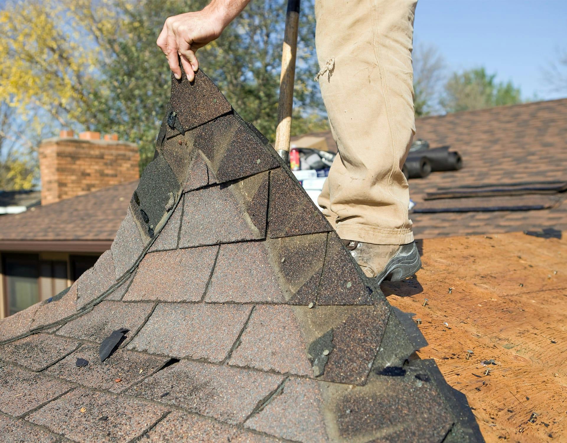 man lifting up roof tile