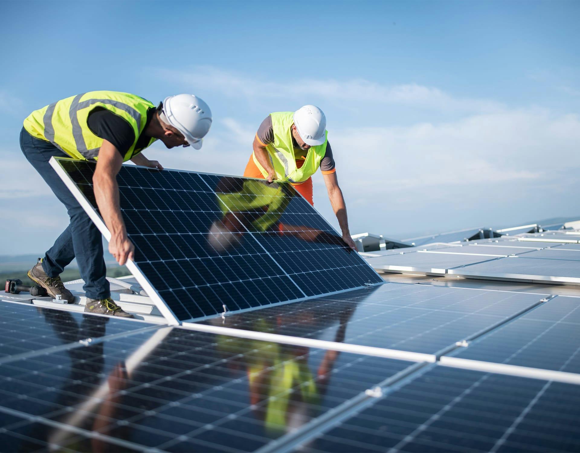 two workers laying a solar panel