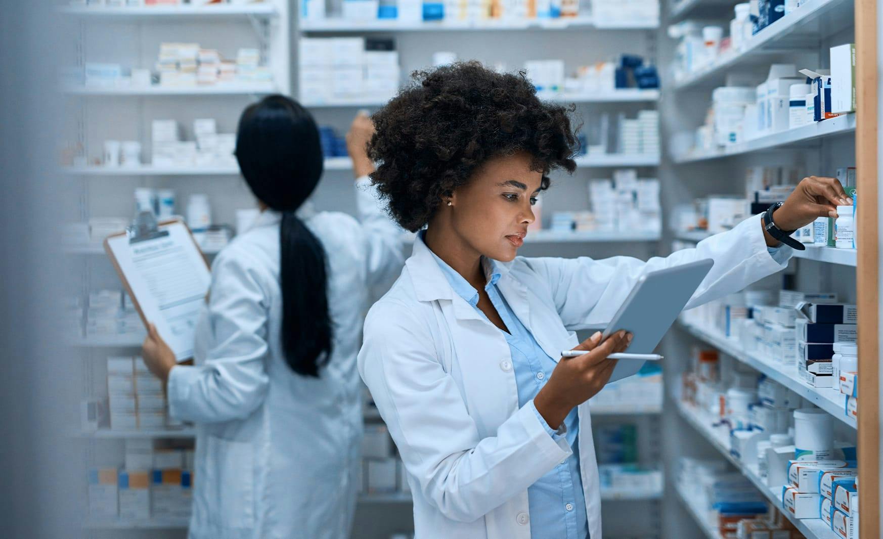 2 women in a lab looking at medicine