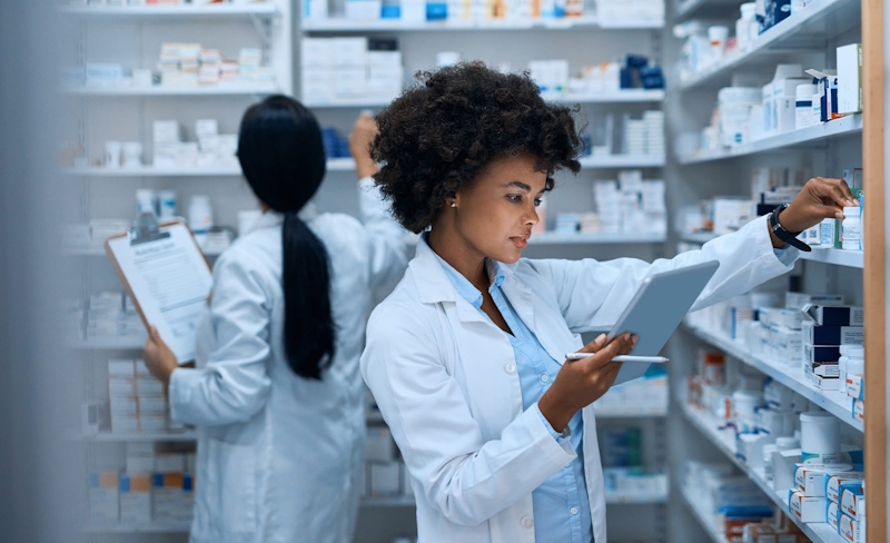 2 women in a lab looking at medicine