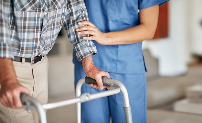 man writing on notepad with a person looking at him