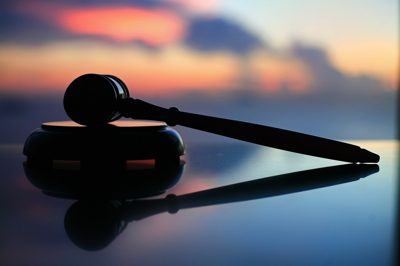 A judge's gavel and block against a blurred sunset background