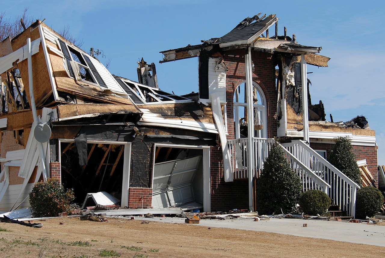 A two-story brick house severely damaged by fire.