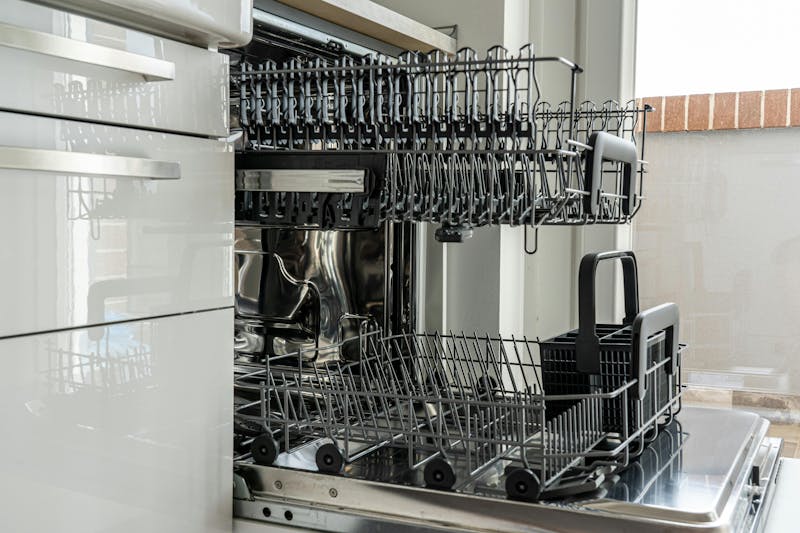 Open dishwasher with empty racks, showing the interior design and metal dish holders.