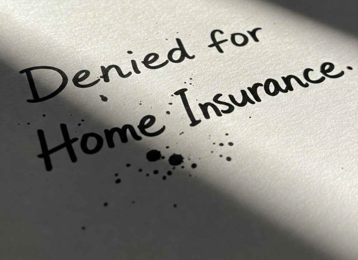 The words "Denied for Home Insurance" are written on paper with ink splatters around them.