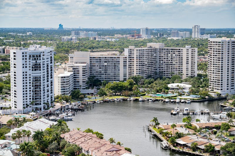 Aerial view of waterfront condominiums with boats docked along the marina.