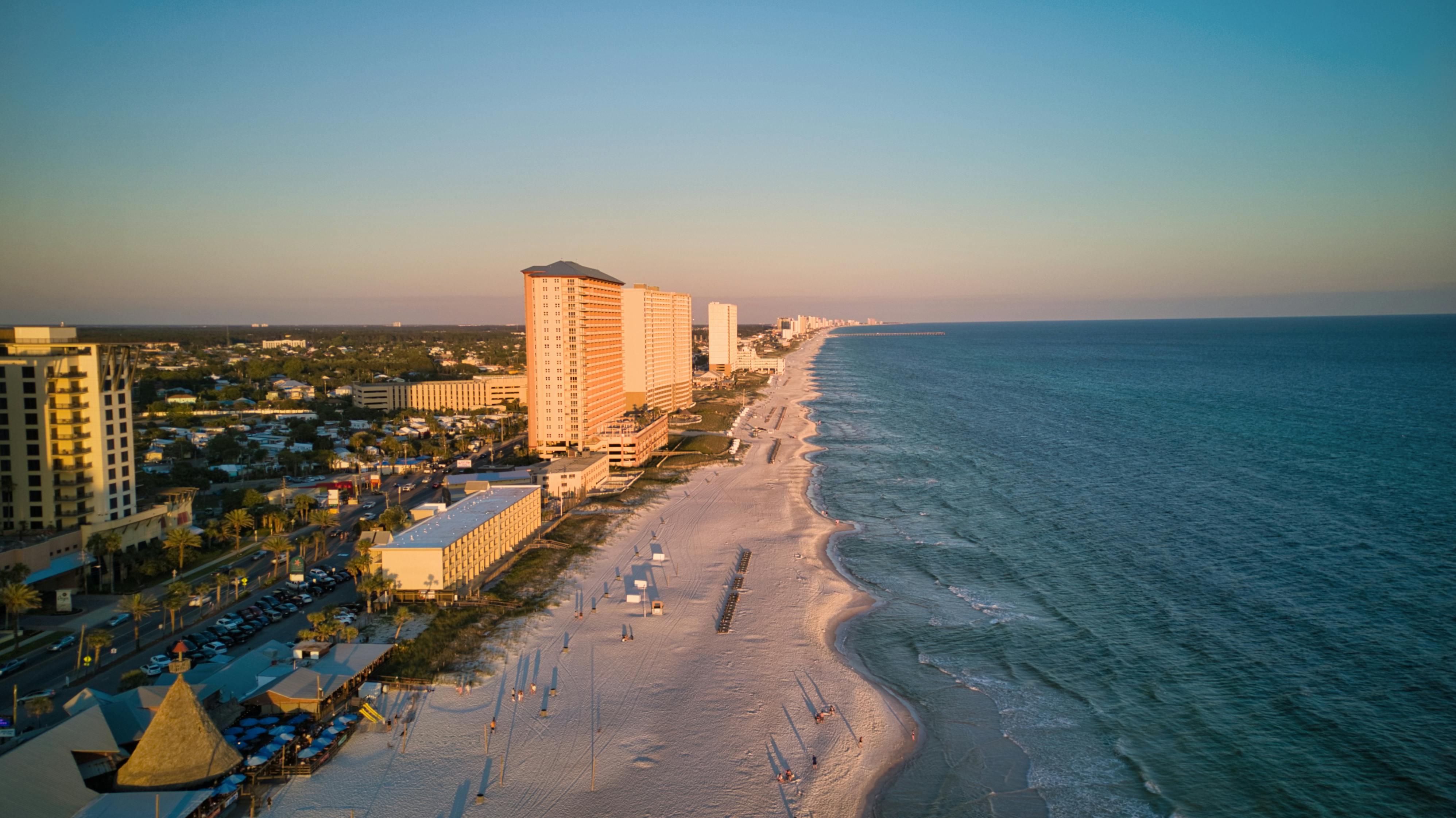 Beachfront condominiums along a scenic coastline at sunset.