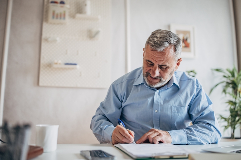 Older man signing papers