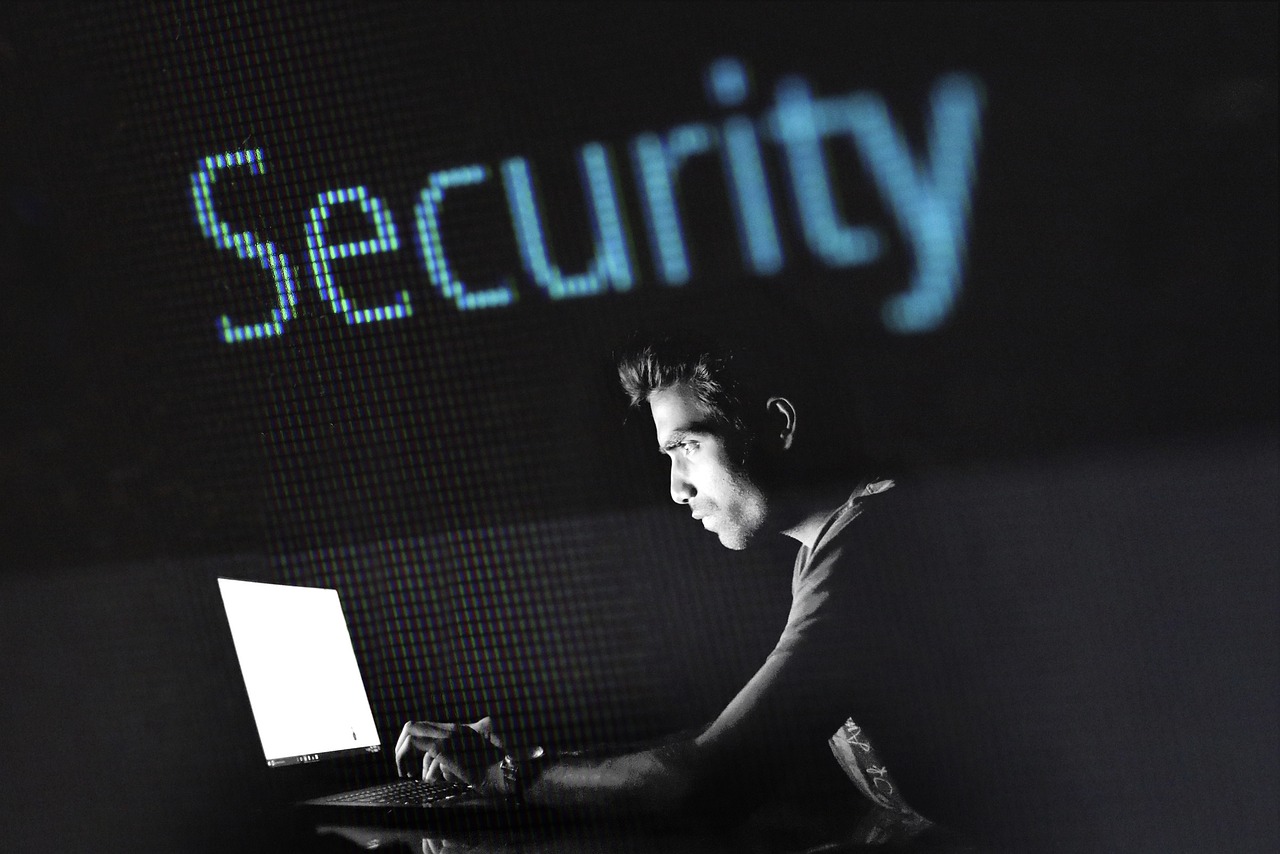 Man using laptop with the word “Security” displayed in the background