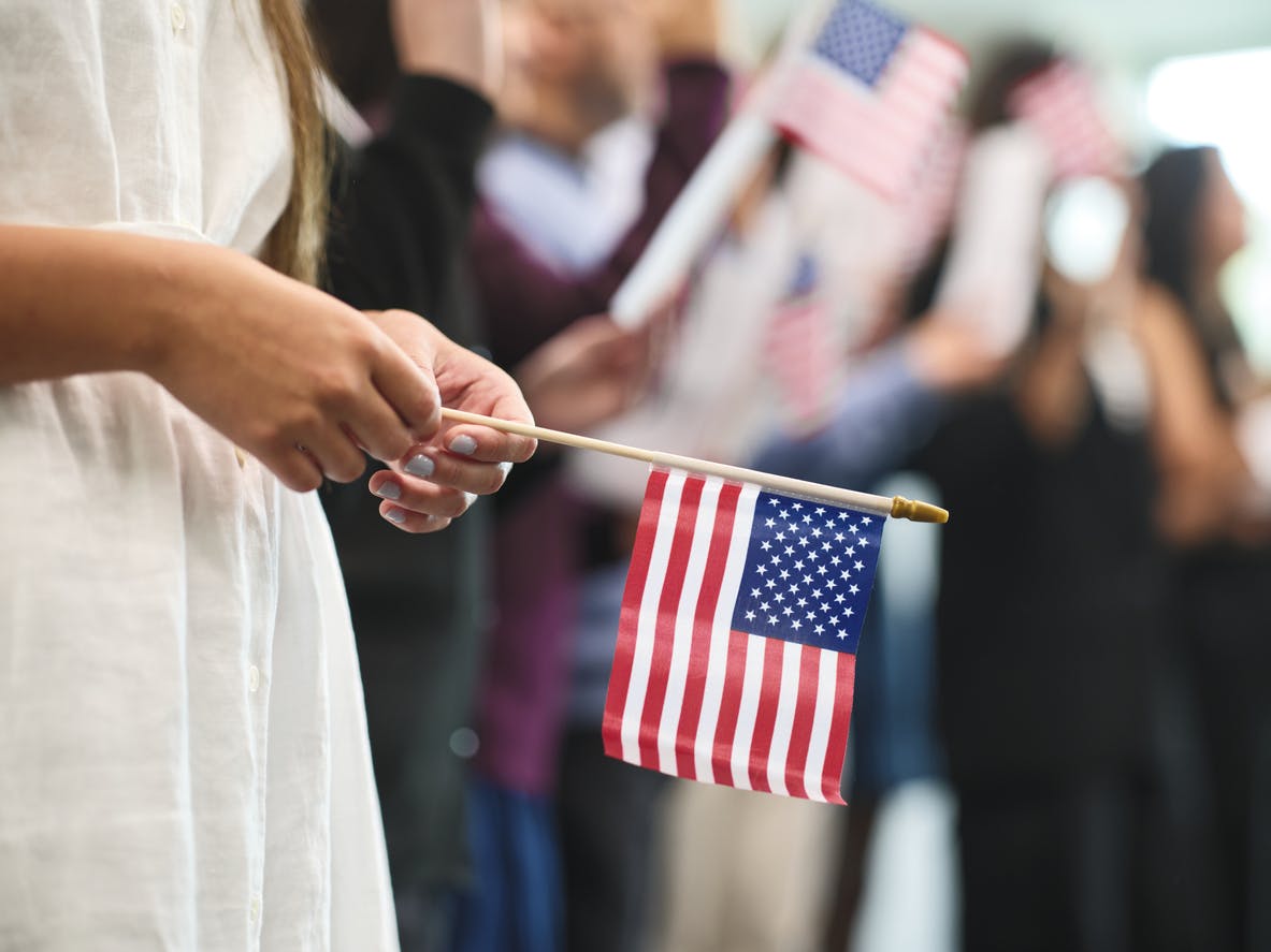 Green Card in the USA woman holding an american Flag