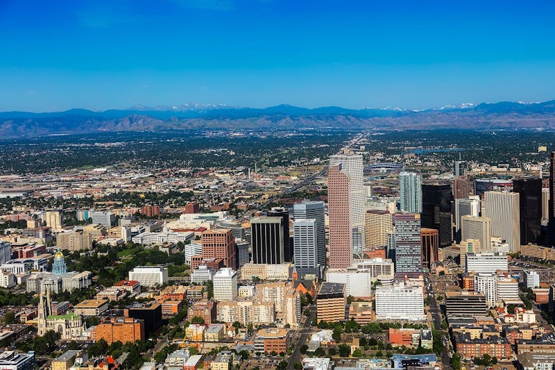 Aerial view of downtown Denver with mountains in the background
