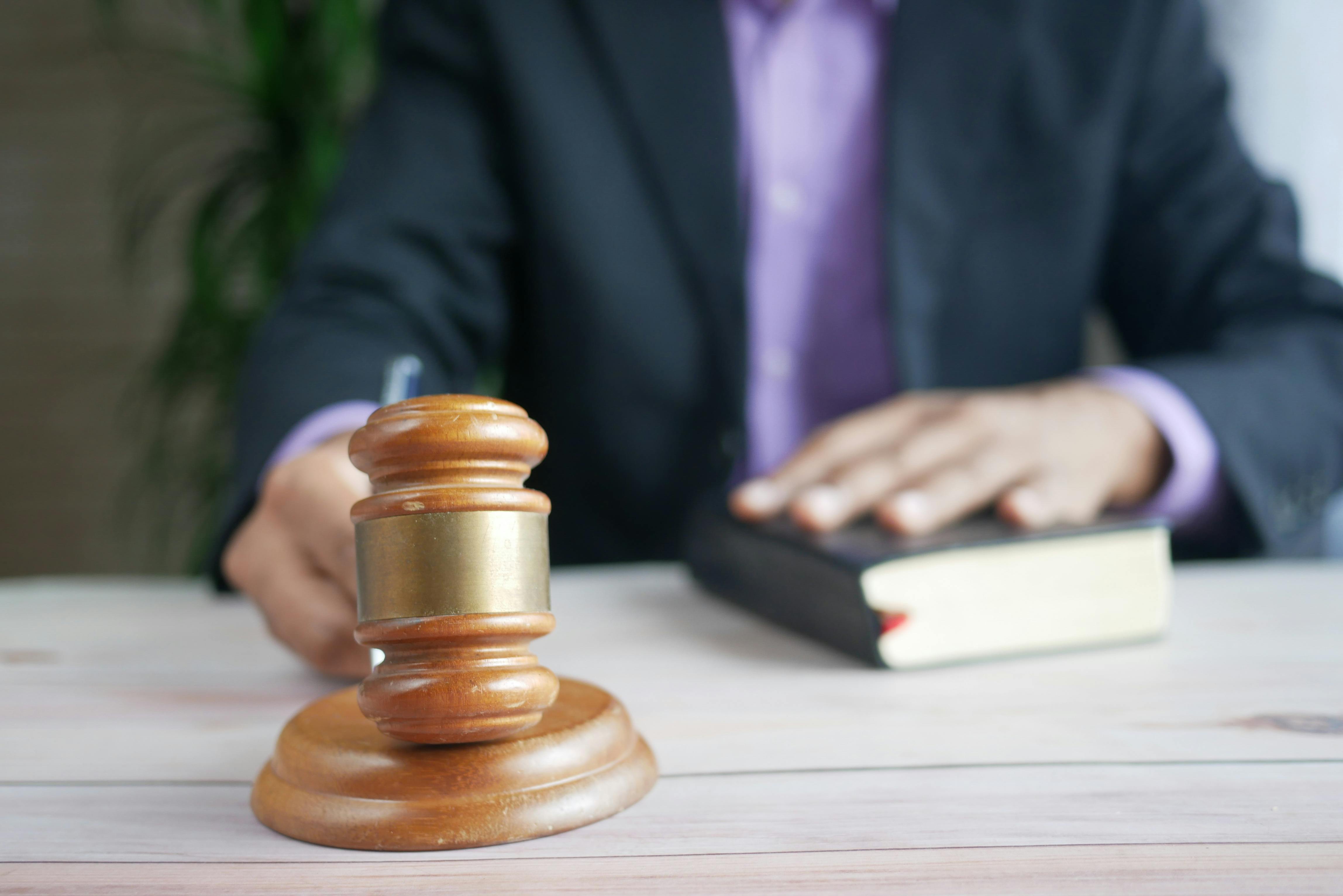 Judge’s gavel on a desk with a person in the background