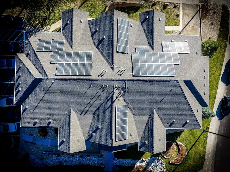 Aerial view of a residential home with rooftop solar panels installed as part of a residential solar system.