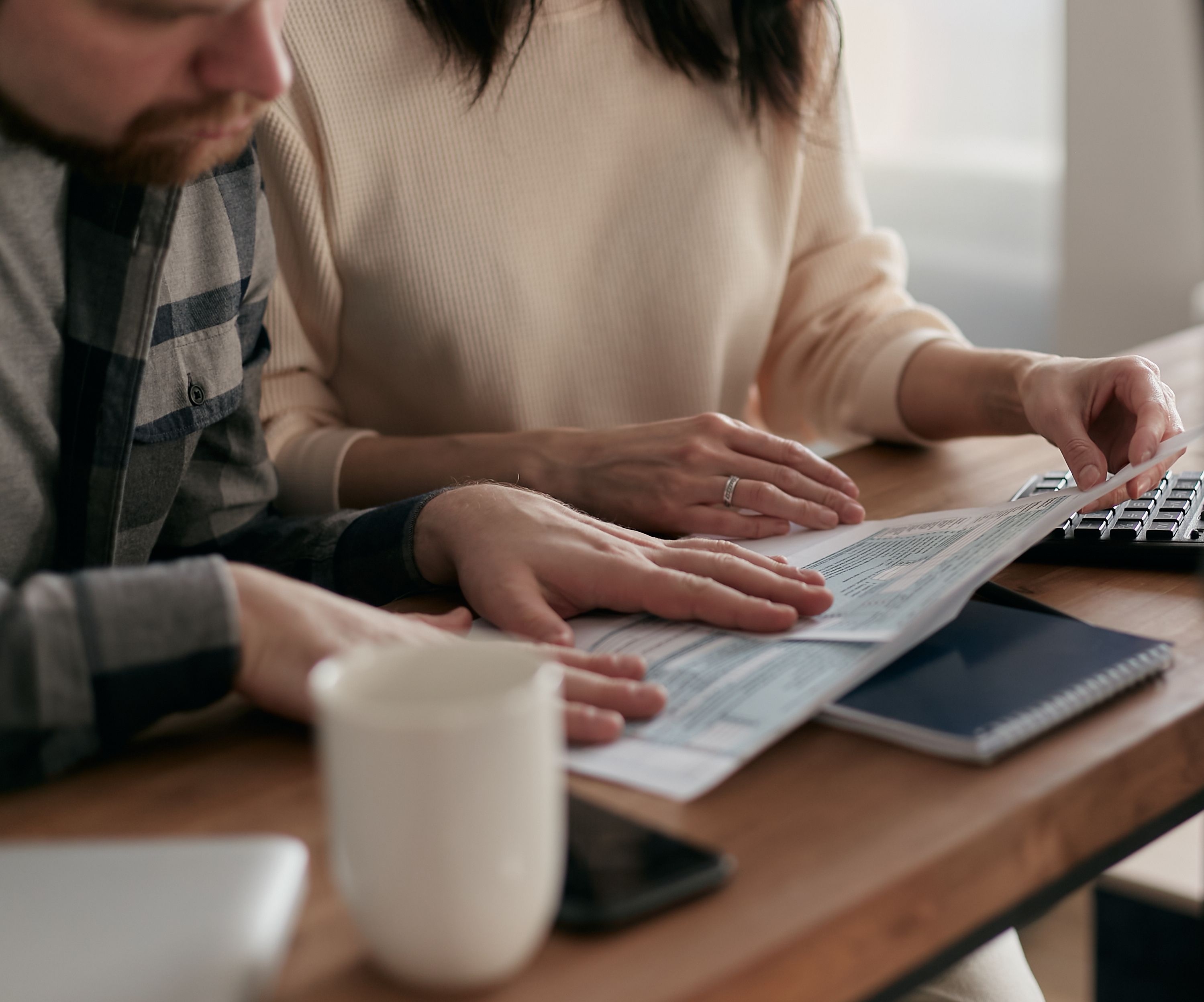 Homeowners reviewing insurance claim documents and policy information while discussing coverage options.