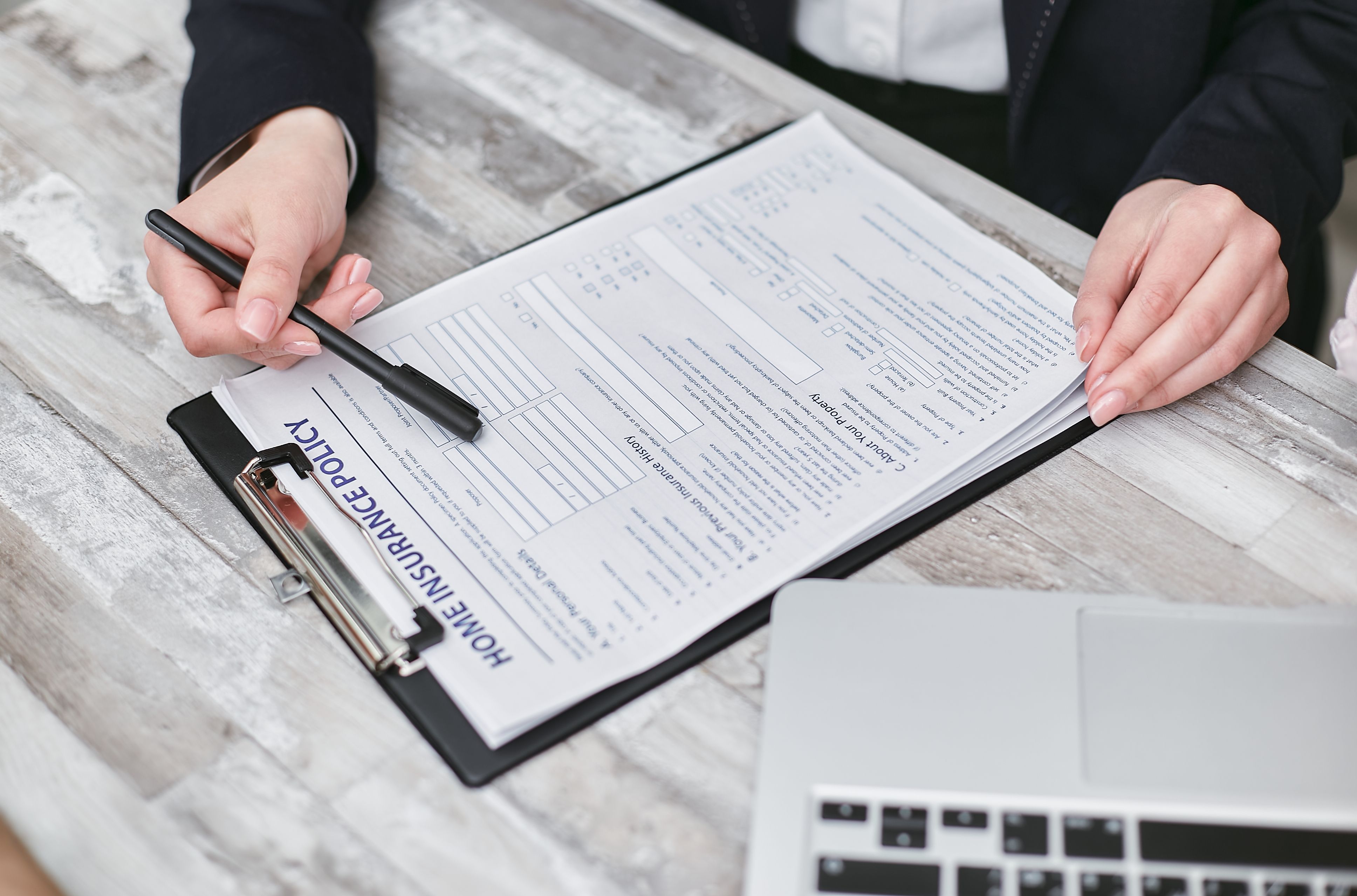 Insurance professional reviewing a homeowner’s insurance policy and coverage details during a claim consultation