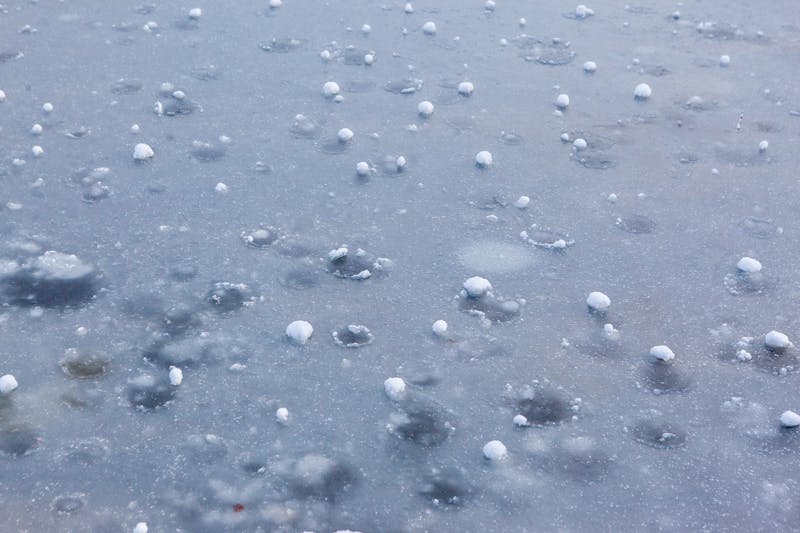 Large hailstones covering the ground after a severe thunderstorm in Texas or Colorado.