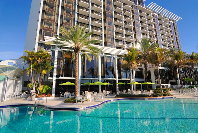 A pool in front of a hotel