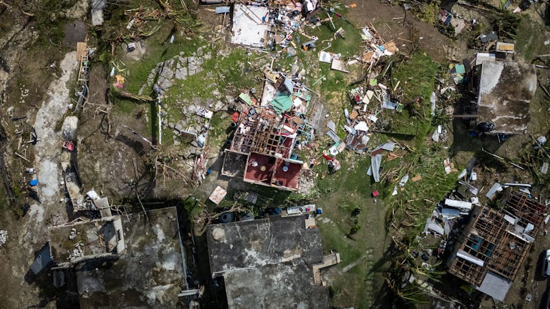 Aerial view of homes and debris after severe hurricane or storm damage.