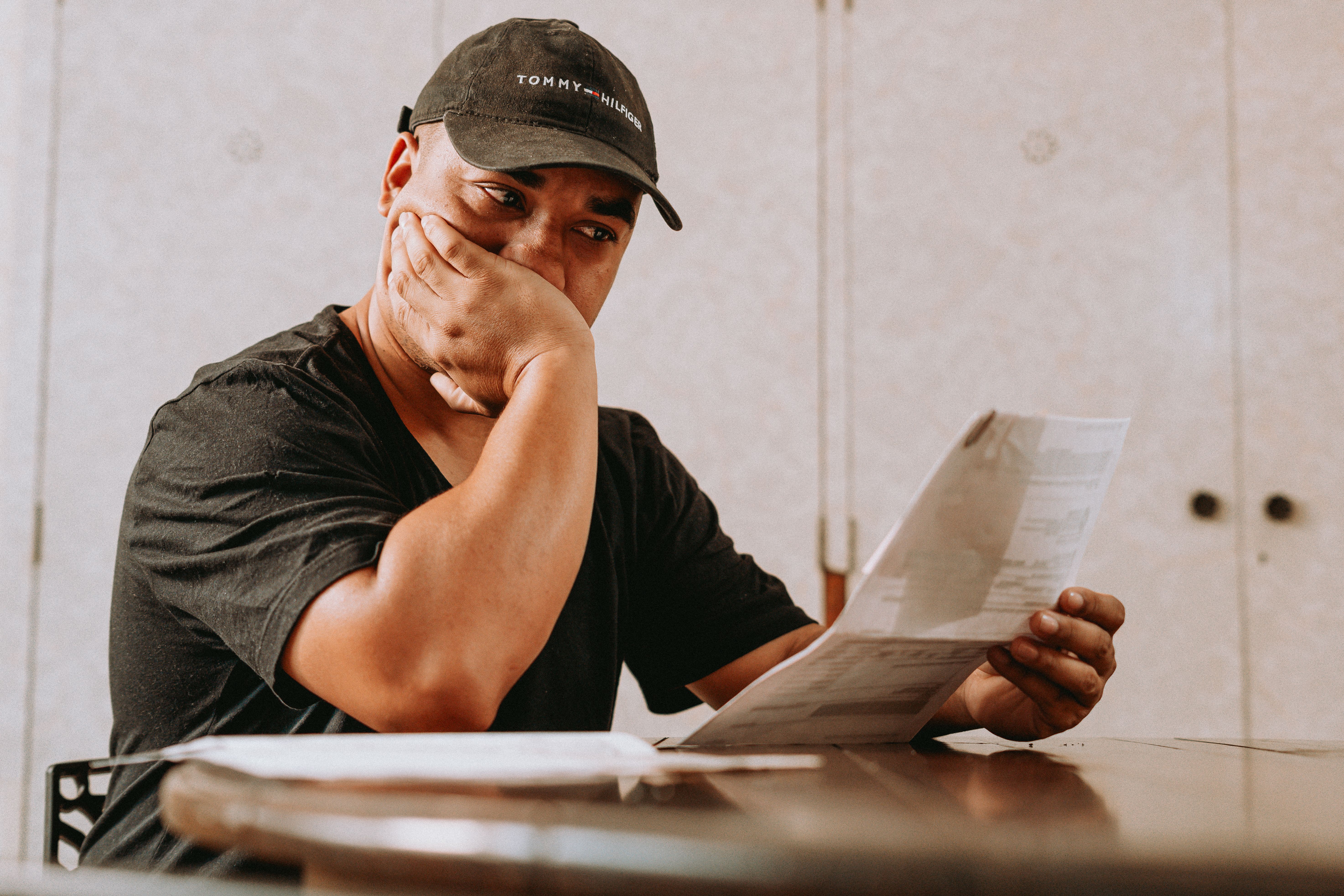 Concerned property owner reviewing insurance documents while sitting at a table.