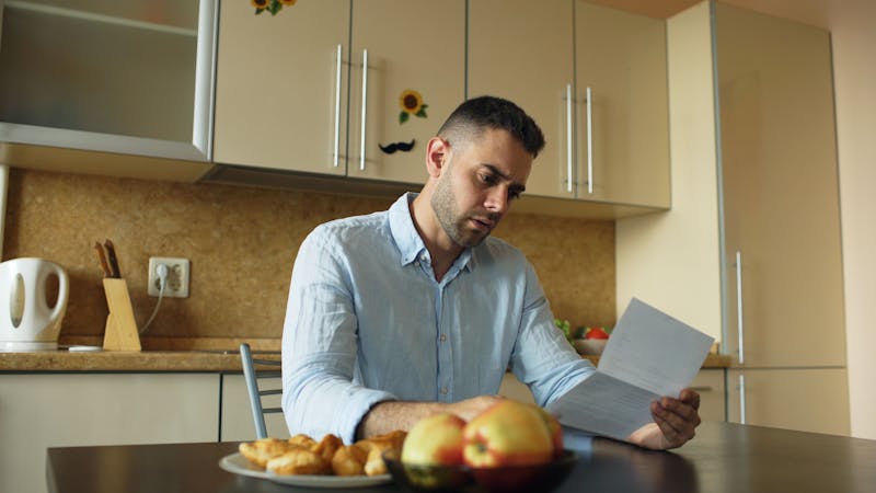 Homeowner reviewing bills and expenses related to a property insurance claim.