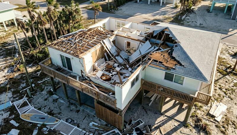 Severe hurricane roof damage to a coastal Florida home, exposing wooden beams and interior rooms.