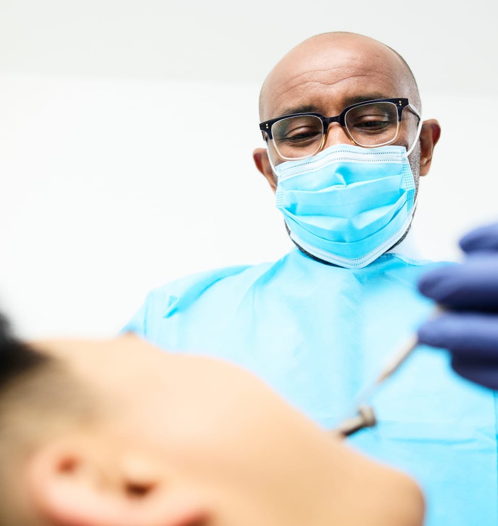 Dr. Sinada performing dental surgery on a patient