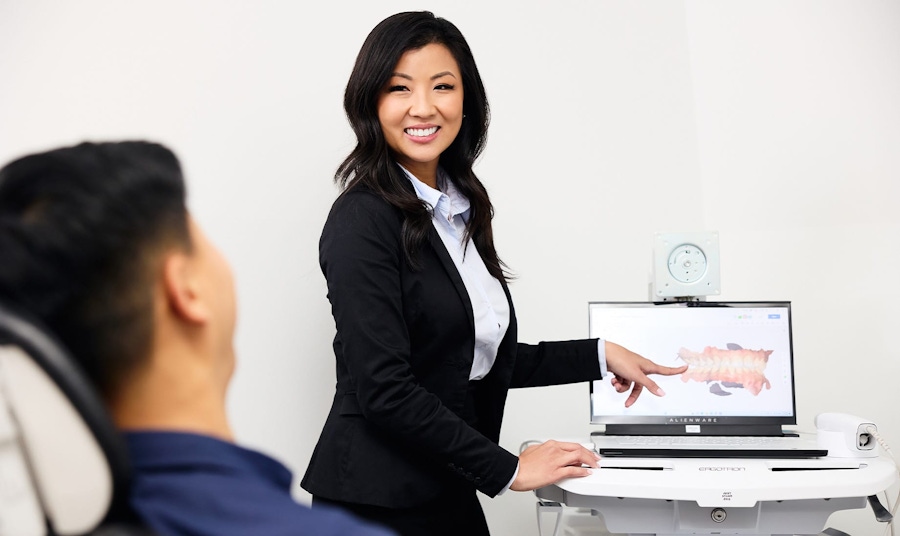 dr lucy showing patient his teeth in a 3D form on a laptop