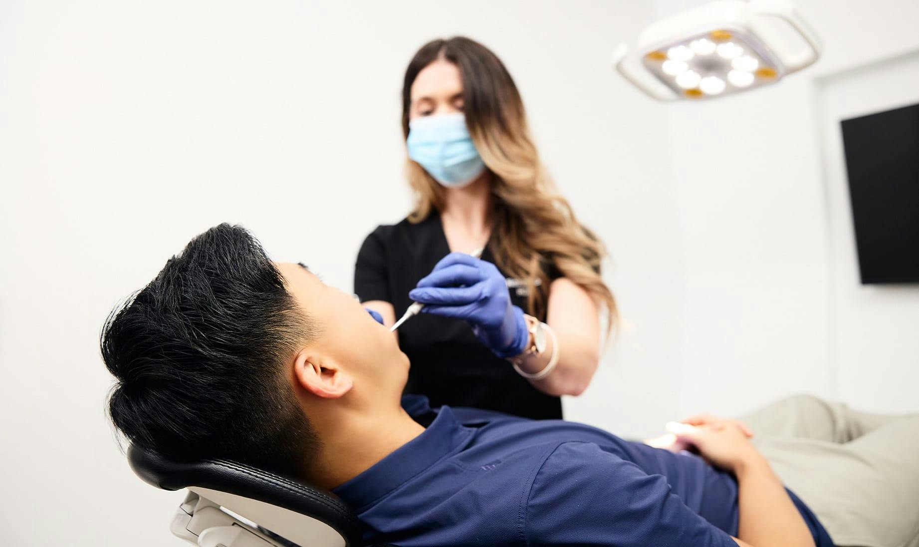 Dental assistant with a teeth whitening patient at Sinada Dental