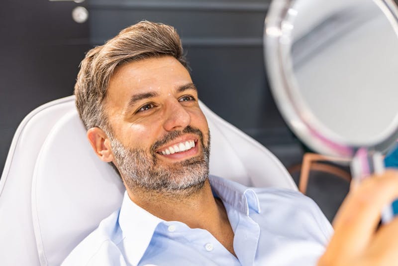 Man smiling into mirror
