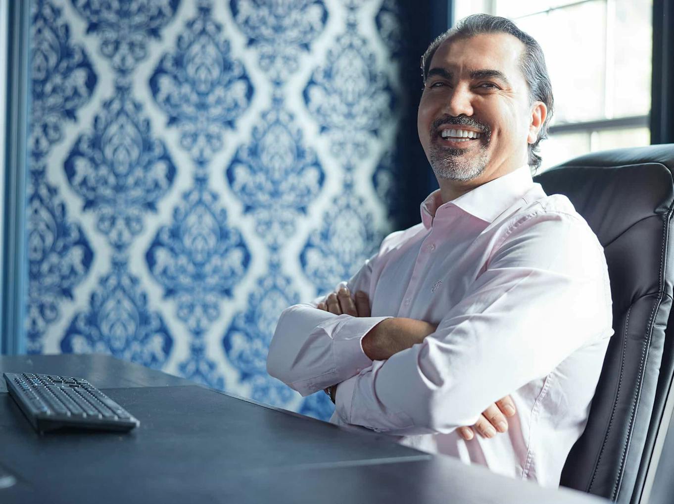 Dr. Aydin sitting at a table laughing