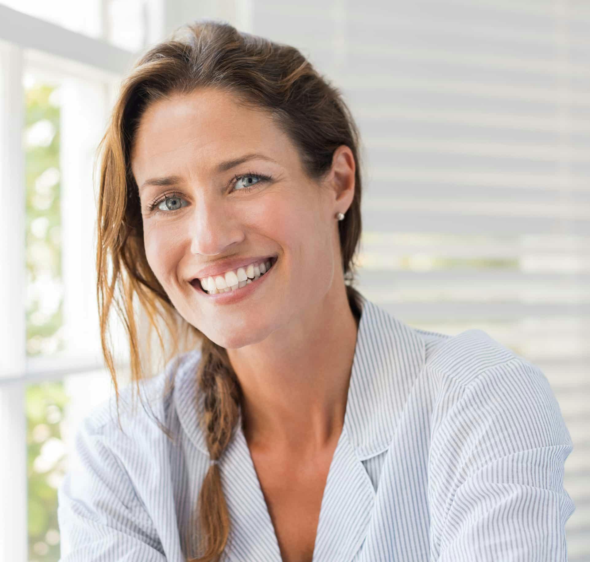 Woman smiling next to a window