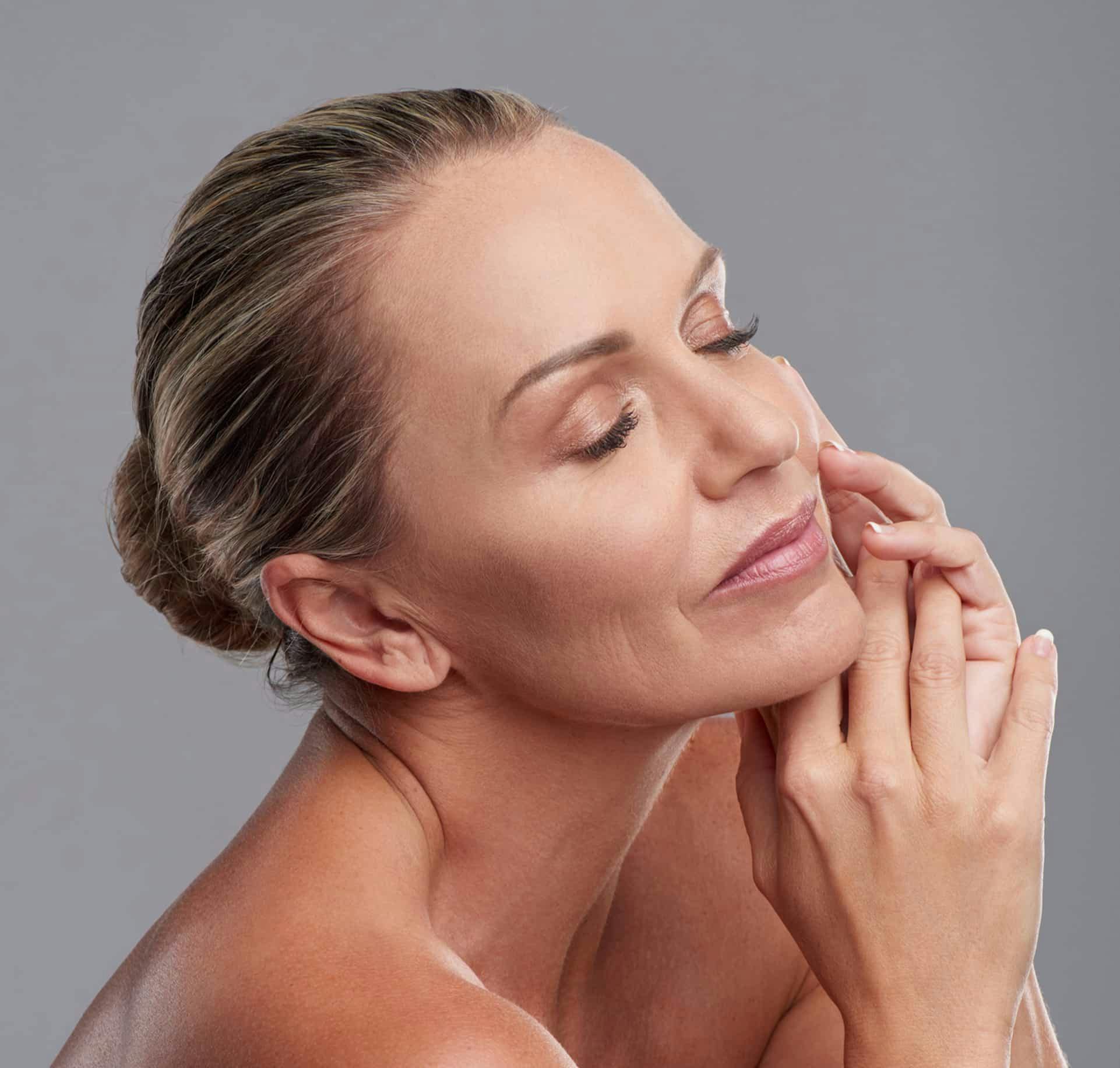 Woman smiling and touching face