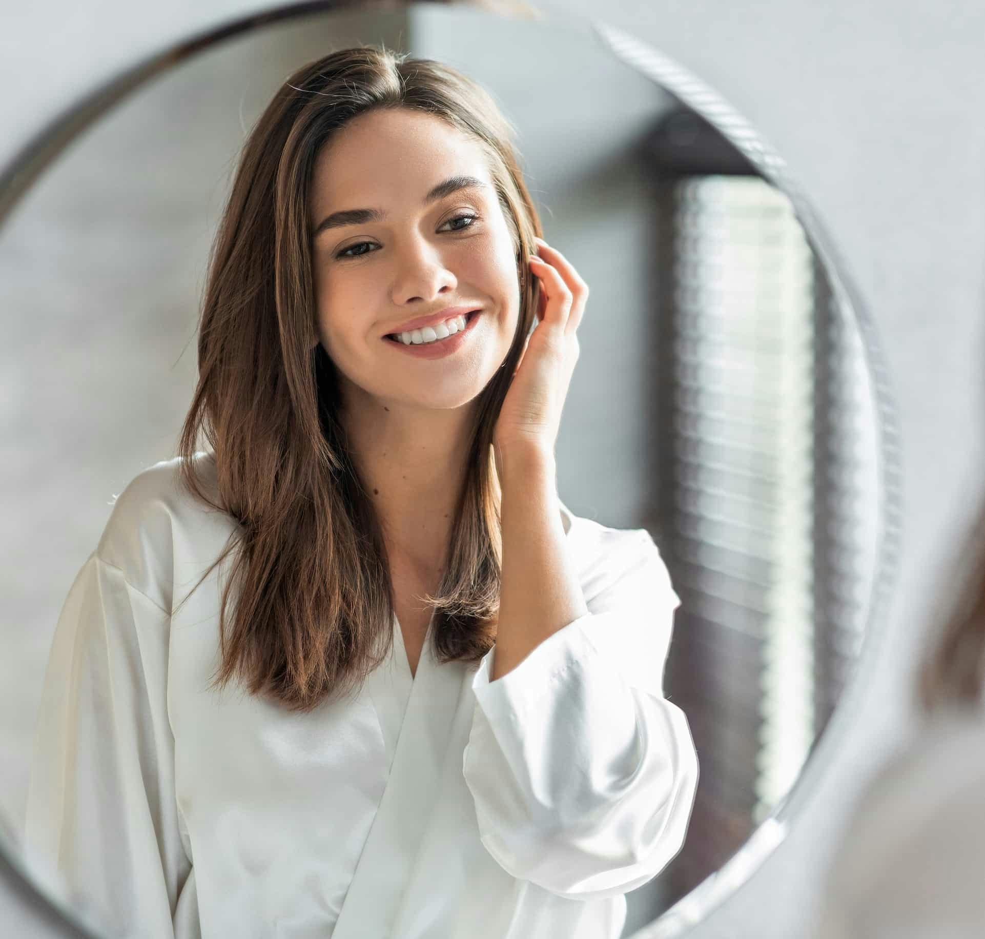 Woman looking in the mirror smiling
