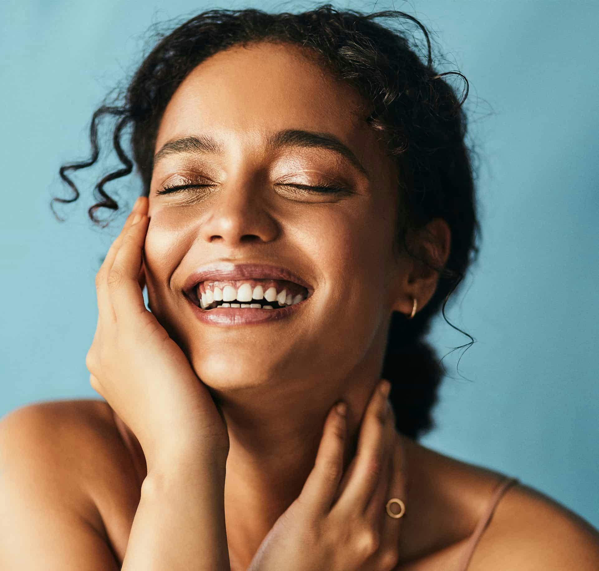 Woman laughing while touching face