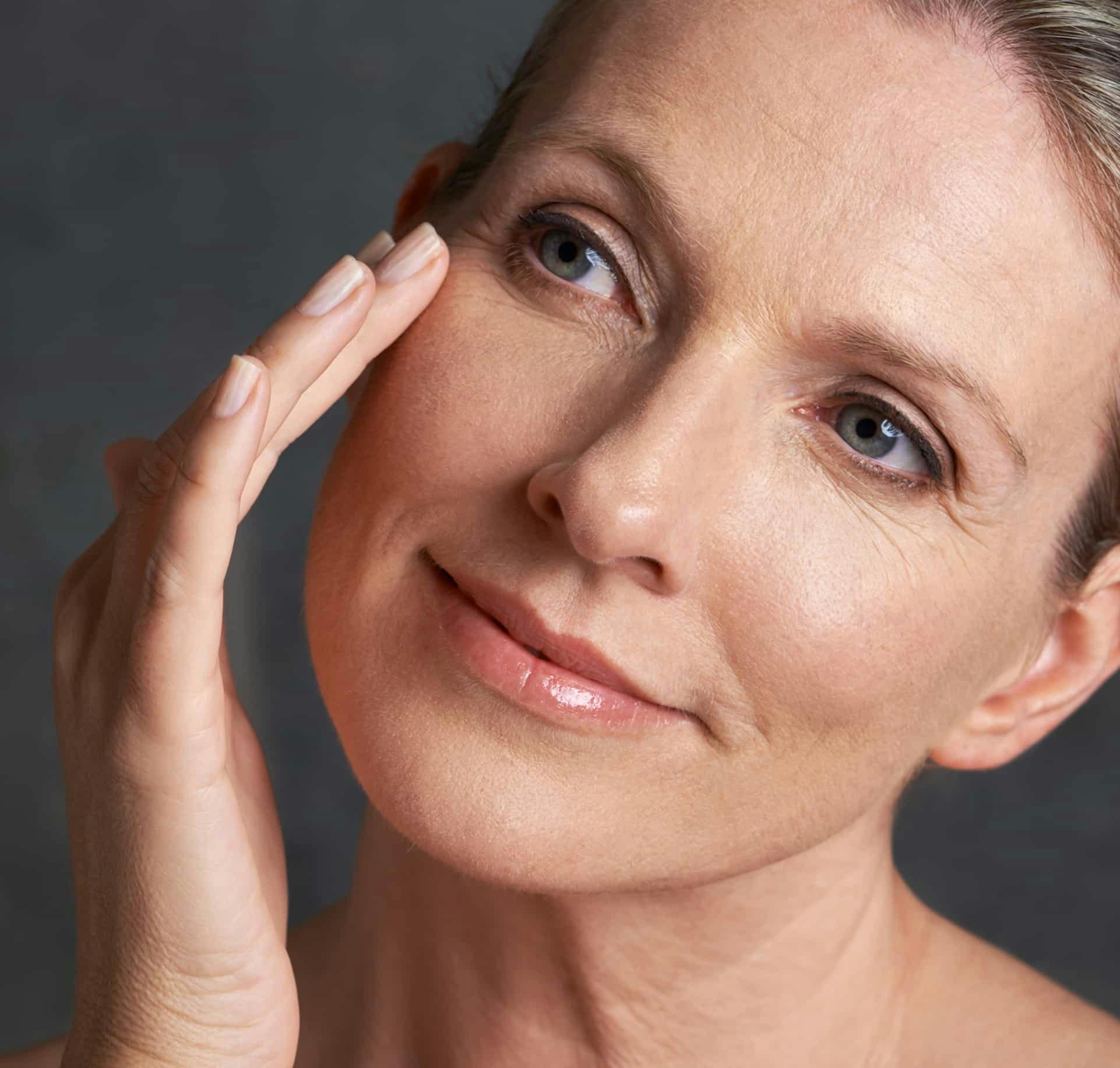 Woman smiling and touching face