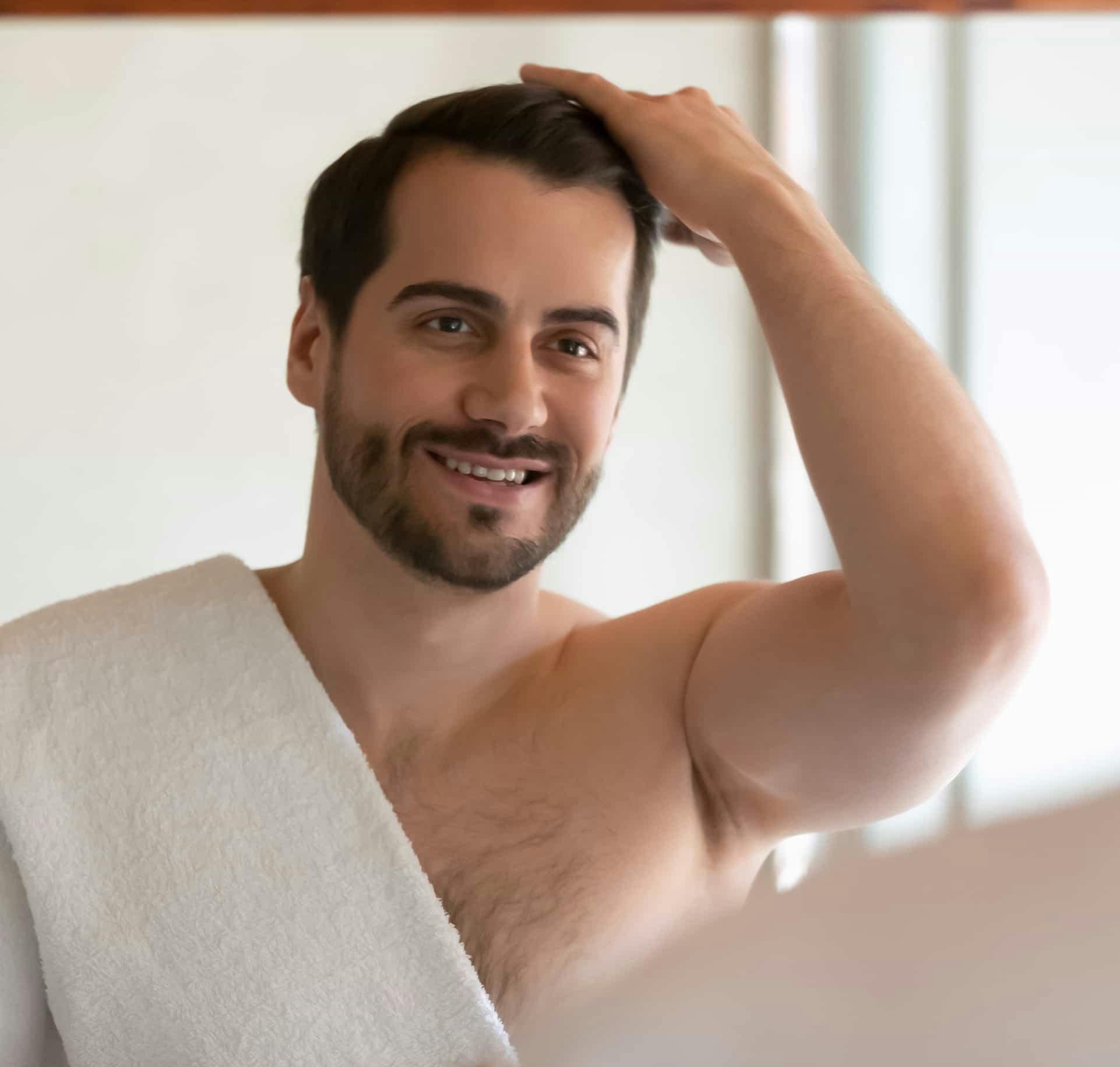 Man running hand through hair and smiling