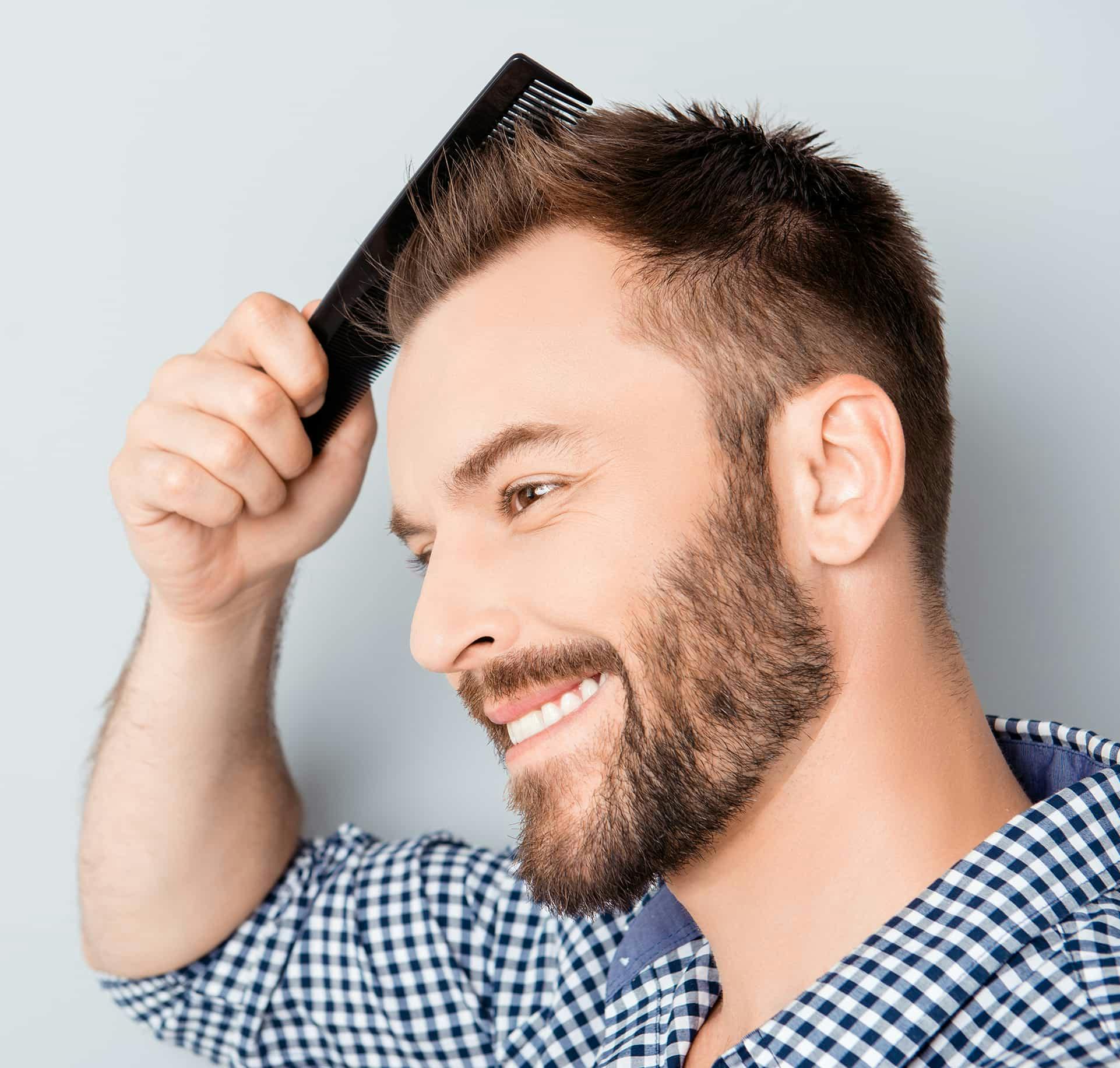 Man smiling while brushing hair