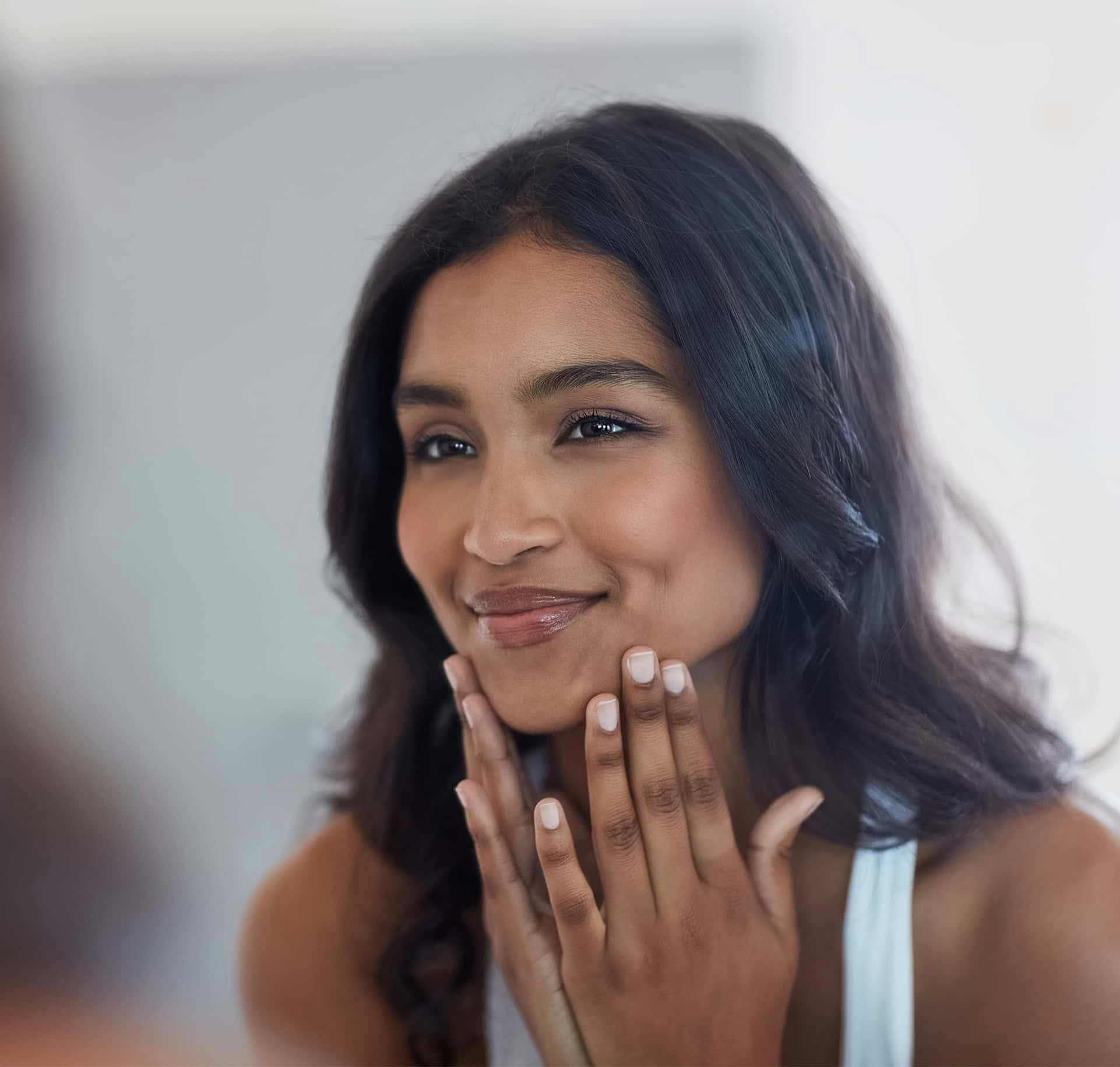 Woman touching face and smiling